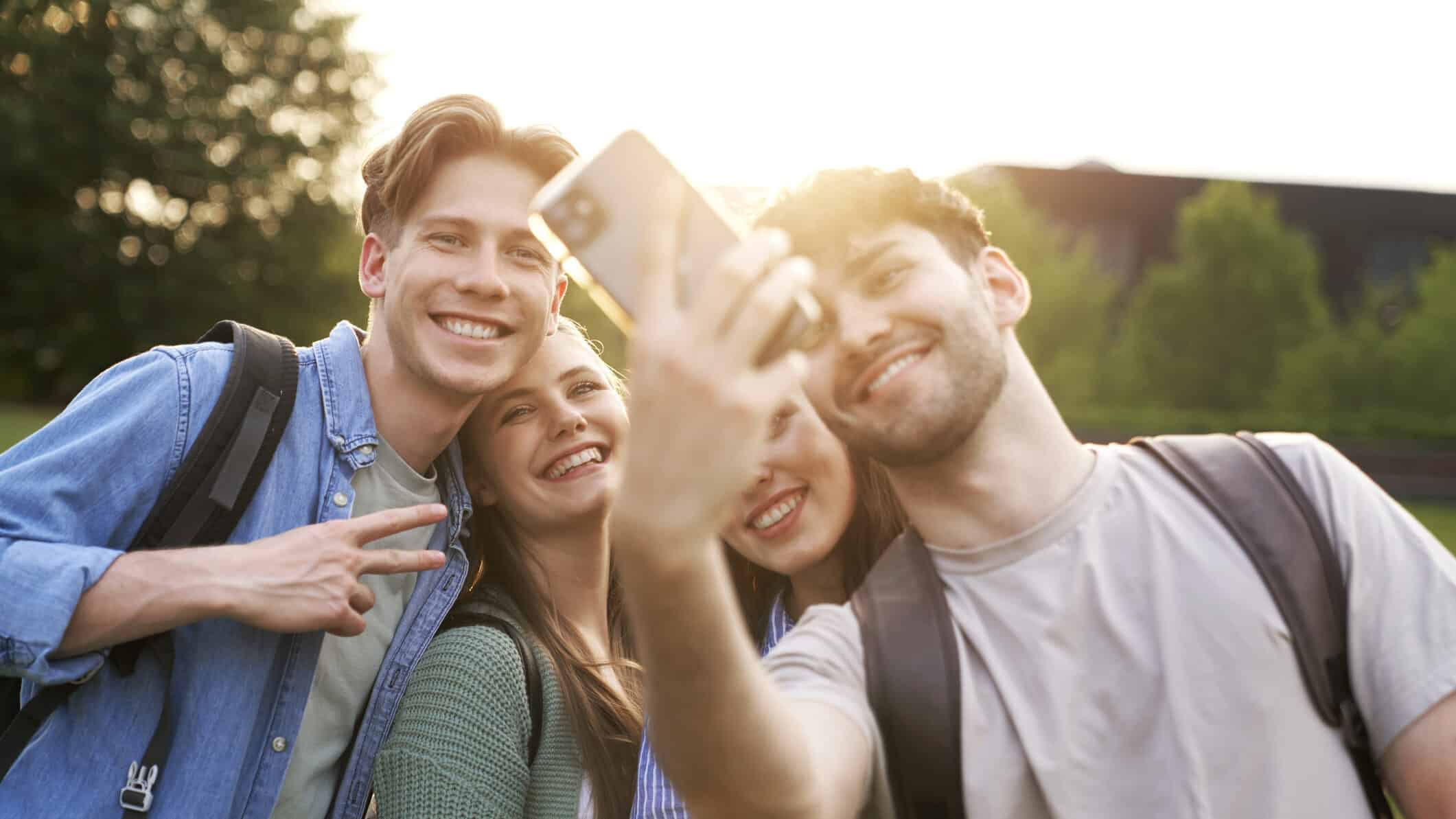 Group of caucasian students taking selfie outside the university campus